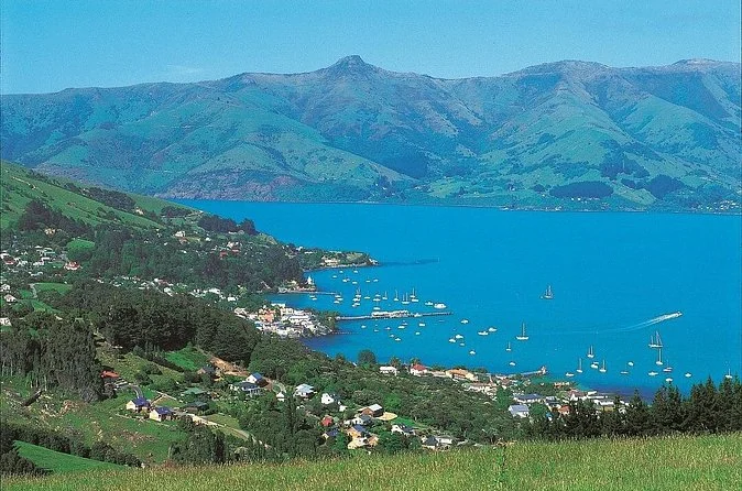 A wide view from the crater rim over Akaroa Harbour, with the town and its moored boats far below